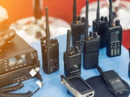 A variety of two-way radio communication devices sit on a table and are being displayed for consumers.