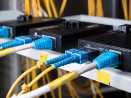 A black box has yellow and white wires with blue plugs, plugged into it. Yellow wires are blurry in the background.