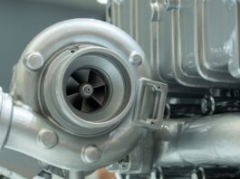 How Airflow Affects Power in Turbocharged Engines A close-up of a diesel engine turbocharger component. The part is silver, very clean, and attached to other components.