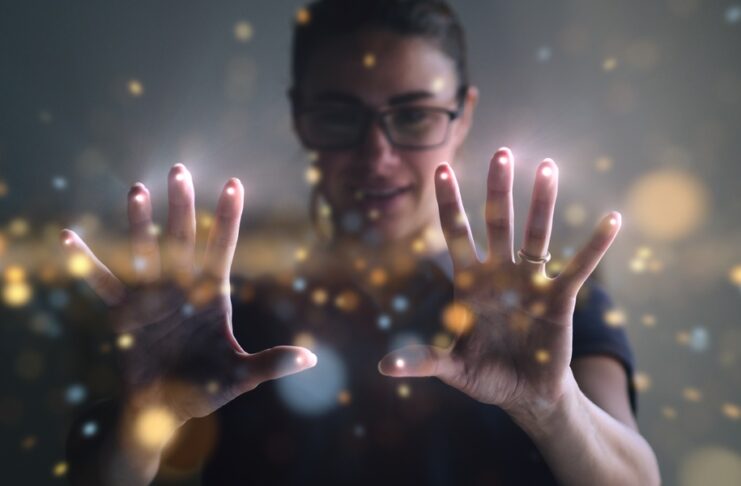 A young woman is using the latest technology, an augmented-reality hologram that's attached to her fingertips.