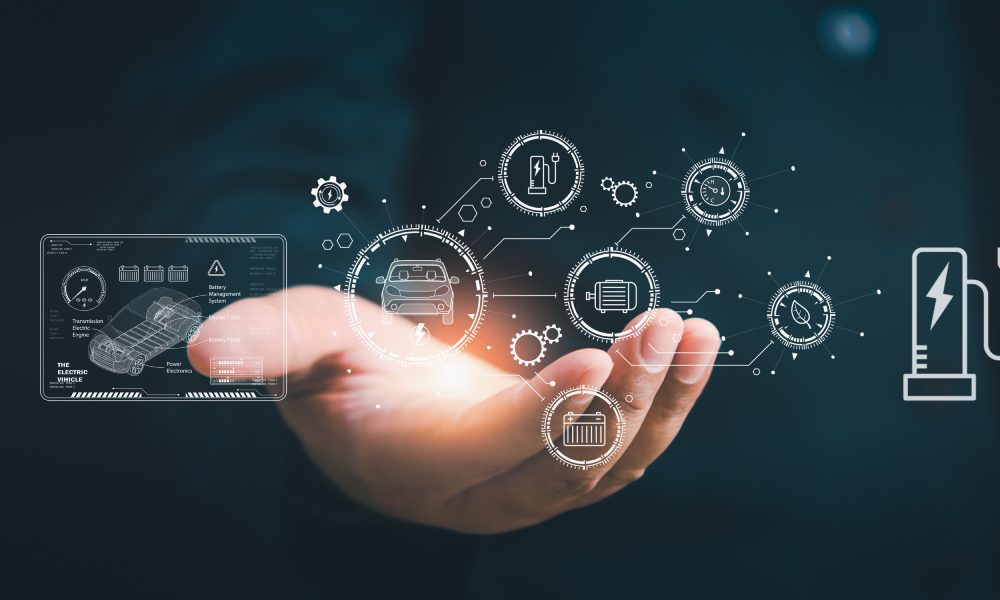A person's hand is holding digital icons for electric vehicles, battery charging, and connected automotive technology.