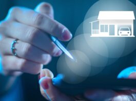A person uses a smartphone as a glowing home and garage hologram appears above the screen in white light.
