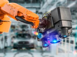 How Machine Vision Is Changing Modern Factories An industrial robot uses a machine vision camera system to inspect components on a modern automotive factory floor.